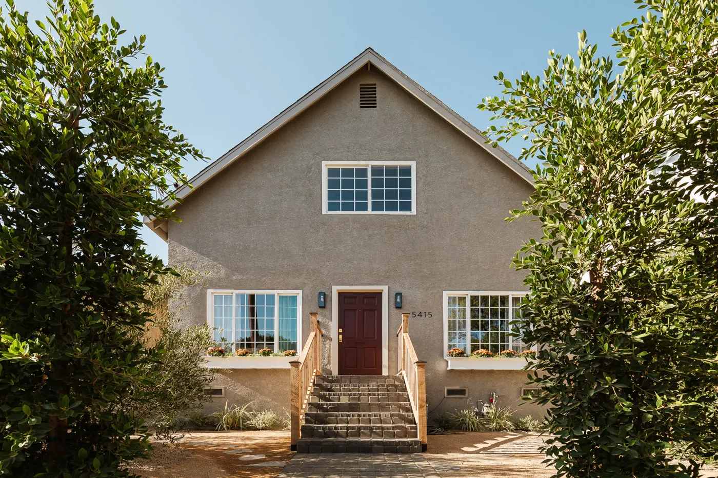5415 Ash in Highland Park, finished: a craftsman house with a steep gable, front steps and mature trees.